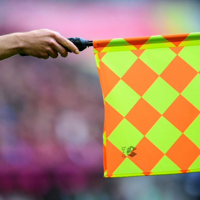 Der Linienrichter hält die Fahne und zeigt Abseits an.