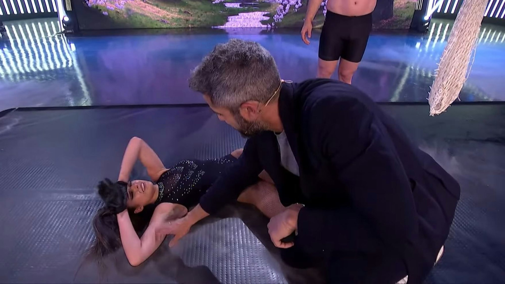 Marta Díaz liegt nach ihrem Tränen-Auftritt bei der spanischen TV-Show „El Desafío“ kraftlos am Boden, Moderator Roberto Leal erkundigt sich nach ihrem Wohlergehen.