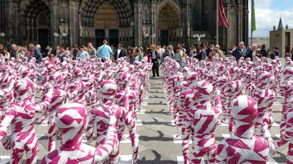 Eine Installation mit Kinderfiguren, die mit Flatterband umwickelt sind, vor dem Kölner Dom erinnert an den Missbrauchsskandal in der katholischen Kirche. (Archivbild)