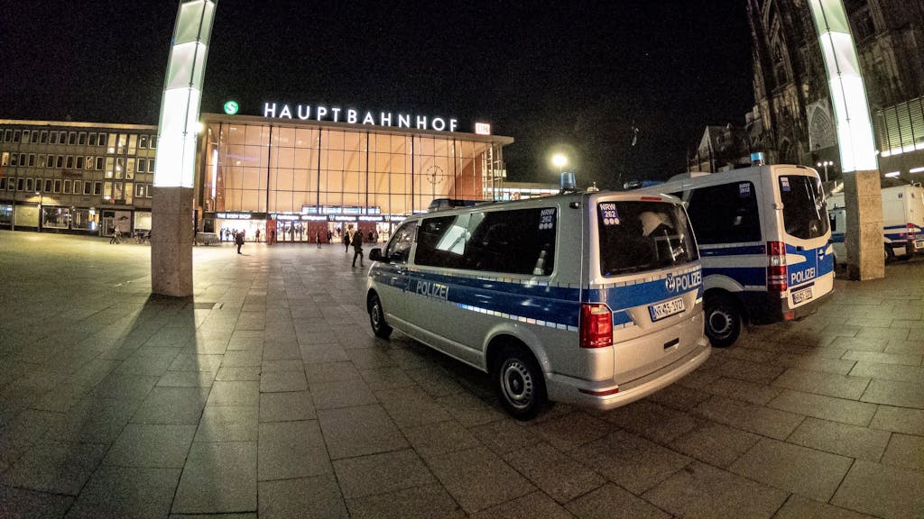 Polizeiwagen stehen vor dem Kölner Hauptbahnhof bei Nacht.