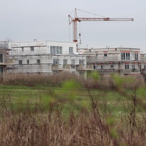 Das Bild zeigt drei im Bau befindliche Mehrfamilienhäuser.