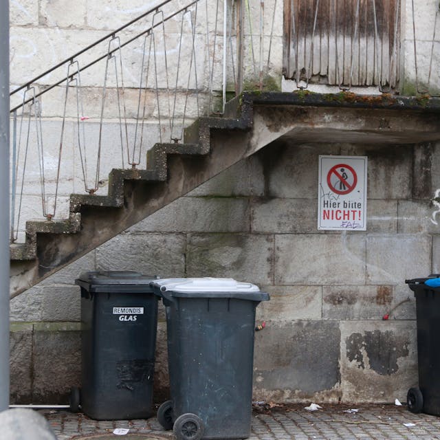 Unter der Treppe vom Eingang von der ehemaligen Pfarrkirche Klein St. Martin ist ein Hinweisschild angebracht "Bitte Nicht" und zeigt eine durchgestrichene Figur die ihre Notdurft verrichtet.&nbsp;