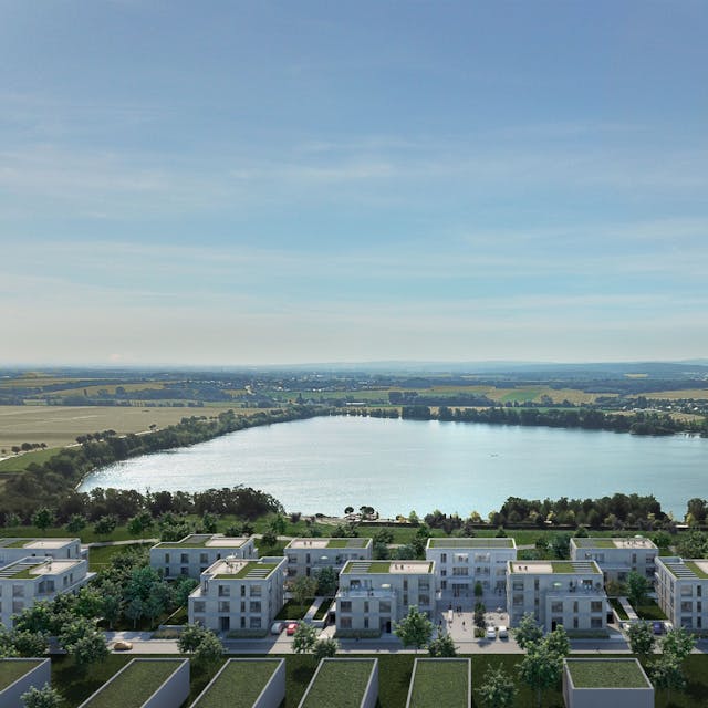 Eine Visualisierung zeigt mehrere helle Gebäude mit Gründächern vor der Kulisse des Zülpicher Wassersportsees.