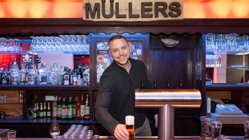 Ein Kellner stellt in der Kneipe „Müllers“ in Köln Ehrenfeld ein Bier auf die Theke.