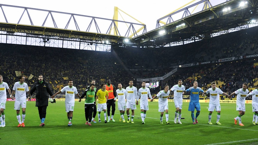 Spieler von Borussia Mönchengladbach feiern mit den Fans im Signal Iduna Park.