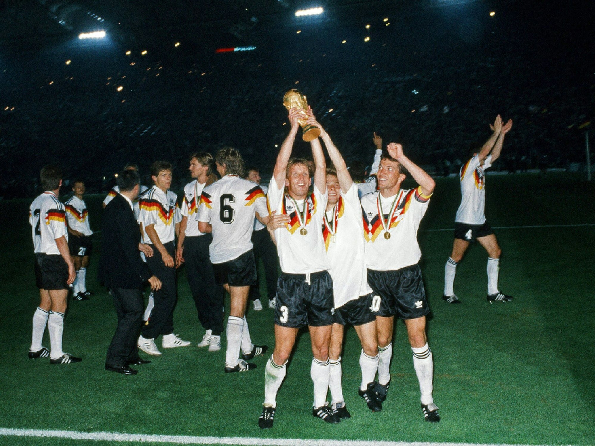 Andreas Brehme, Thomas Häßler und Lothar Matthäus, mit dem WM-Pokal.