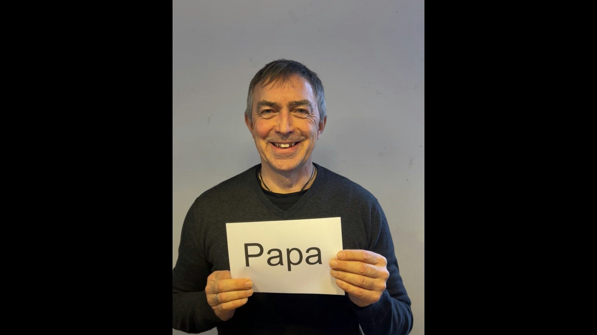 Ralf Gebhardt hält ein Schild vor seiner Brust mit der Aufschrift "Papa".
