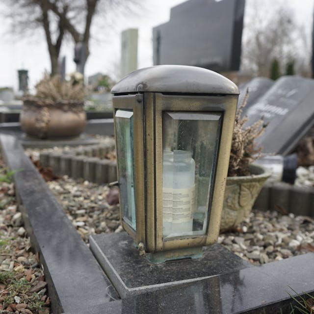 Eine Grablampe auf der Einfassung eines Grabes.