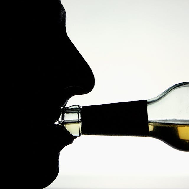 Die Silhouette eines Alkohol trinkenden Mannes