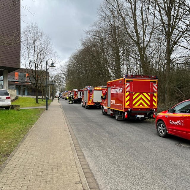 Feuerwehrfahrzeuge stehen an der Straße zur LVR-Schule am Königsforst in Rösrath.