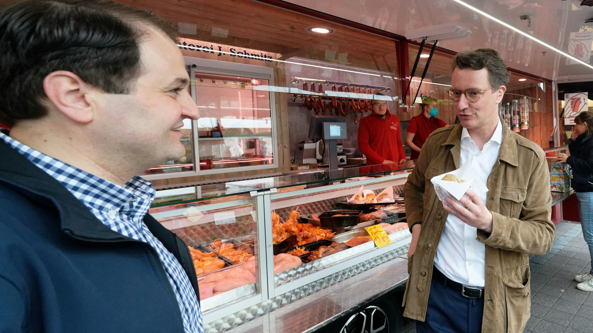 Hendrik Wüst, Spitzenkandidat der CDU zur Landtagwahl (r) und Landtagskandidat Nathanael Liminski (l), sprechen auf dem Markt auf dem Neptunplatz in Köln mit Marktbesuchern.
