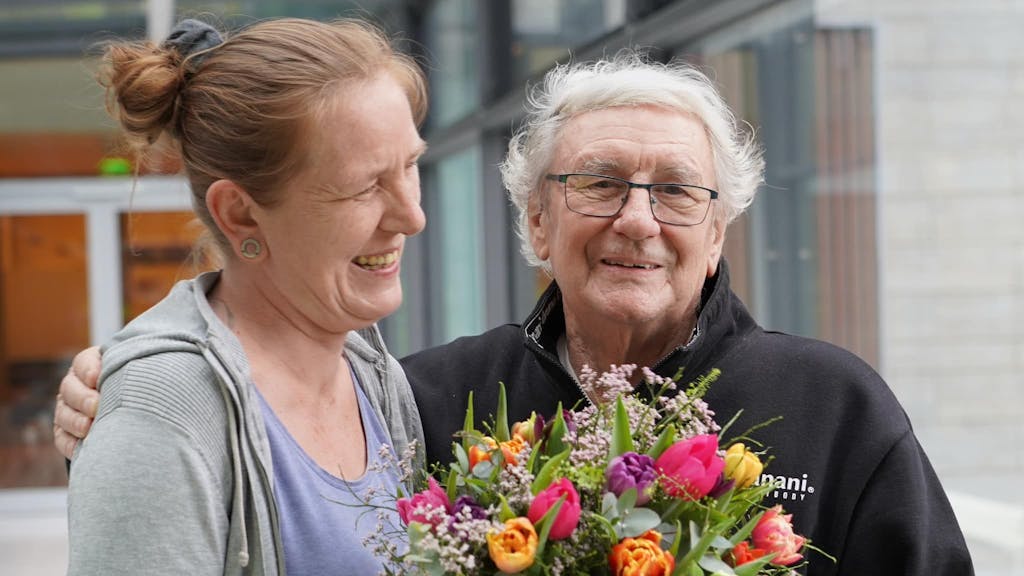 Ein Mann und eine Frau halten einen Blumenstrauß.
