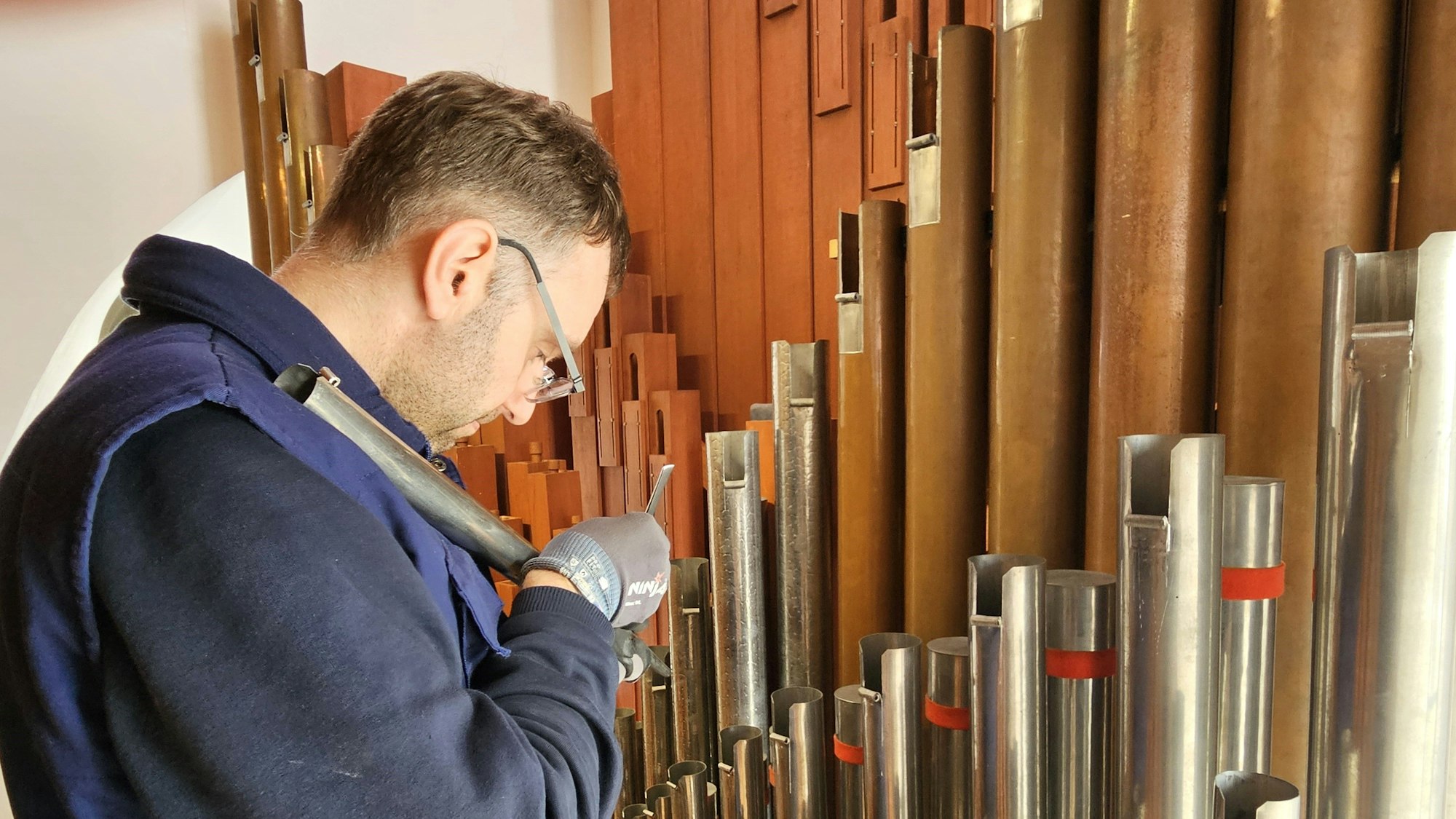 Orgelbaugeselle Markus Moutschen arbeitet an einer Pfeife.