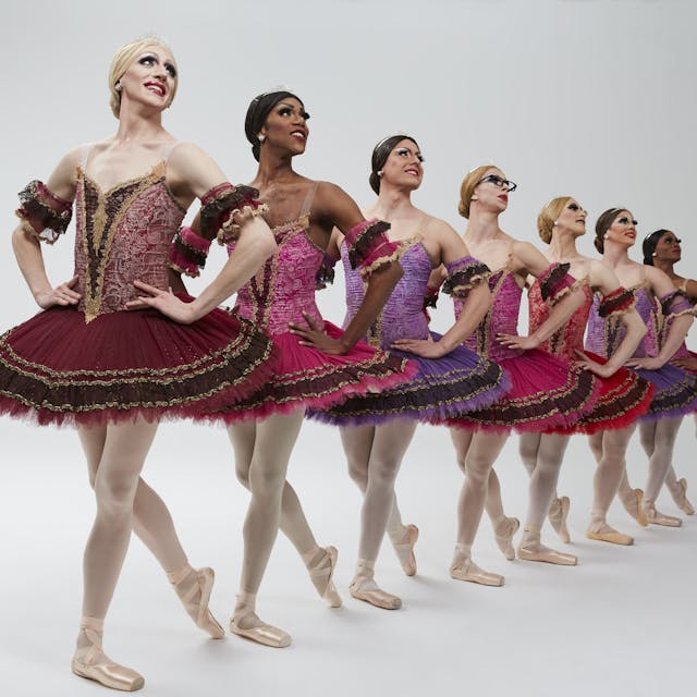 Auf dem Bild sind acht Männer in Balletkleidern zusehen.