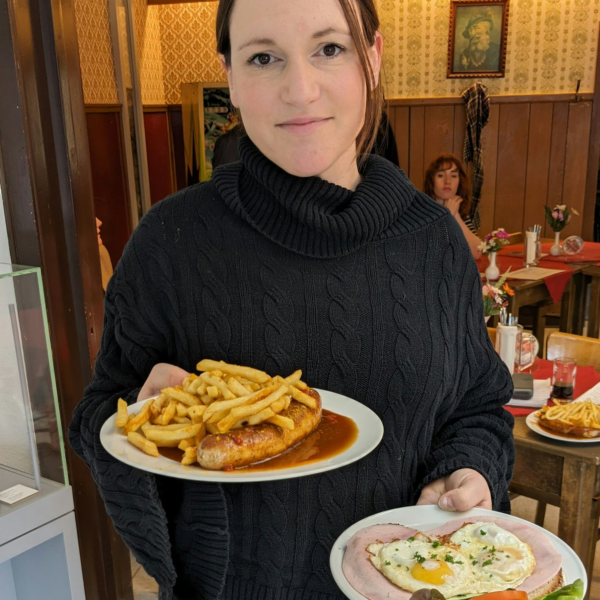 Verena Klein serviert eine Currywurst mit Pommes und einen Teller mit einem „Strammen Max“.
