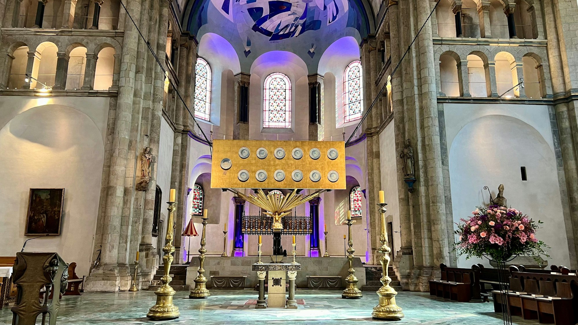 Ein goldenes Bild mit 13 Tellern schwebt über dem Altarraum von St. Aposteln