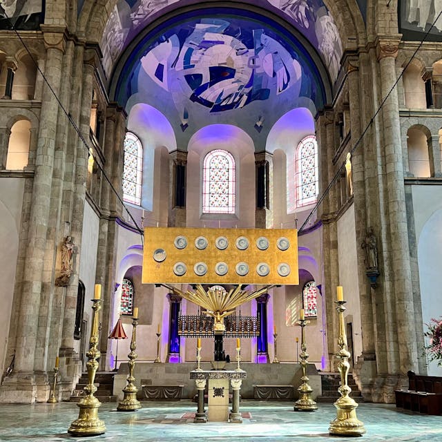 Ein goldenes Bild mit 13 Tellern schwebt über dem Altarraum von St. Aposteln