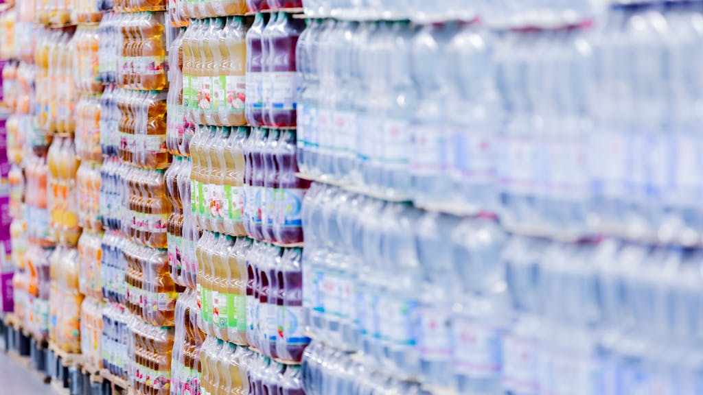 Einweg-Plastikflaschen stehen in einem Supermarkt auf Paletten. Die Supermärkte und Discounter in&nbsp;Deutschland bieten nach Ansicht der Deutschen Umwelthilfe weiterhin zu wenig Waren unverpackt oder in Mehrwegverpackungen an.