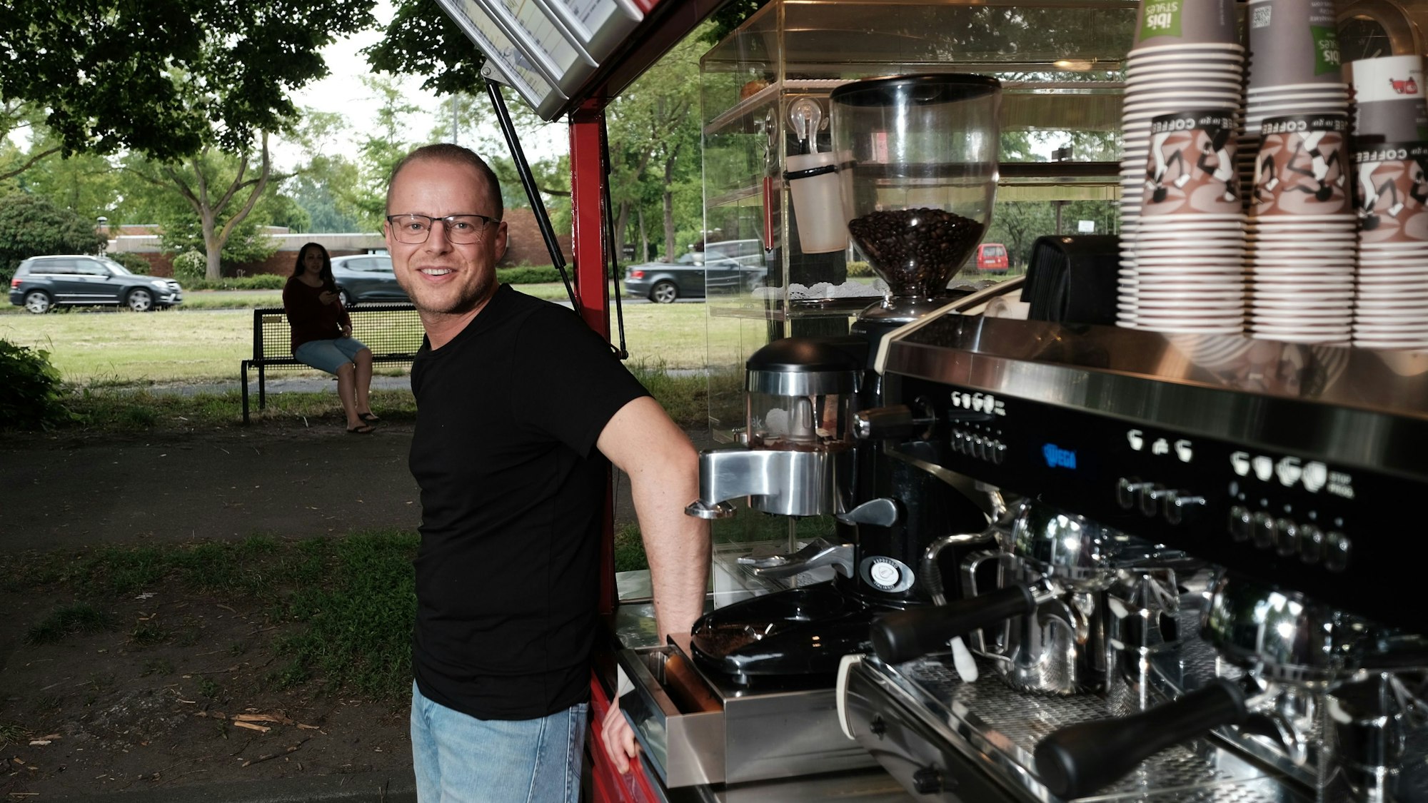 Roberto Mirabile vor seinem Café-Wagen in Köln, er schaut in die Kamera.