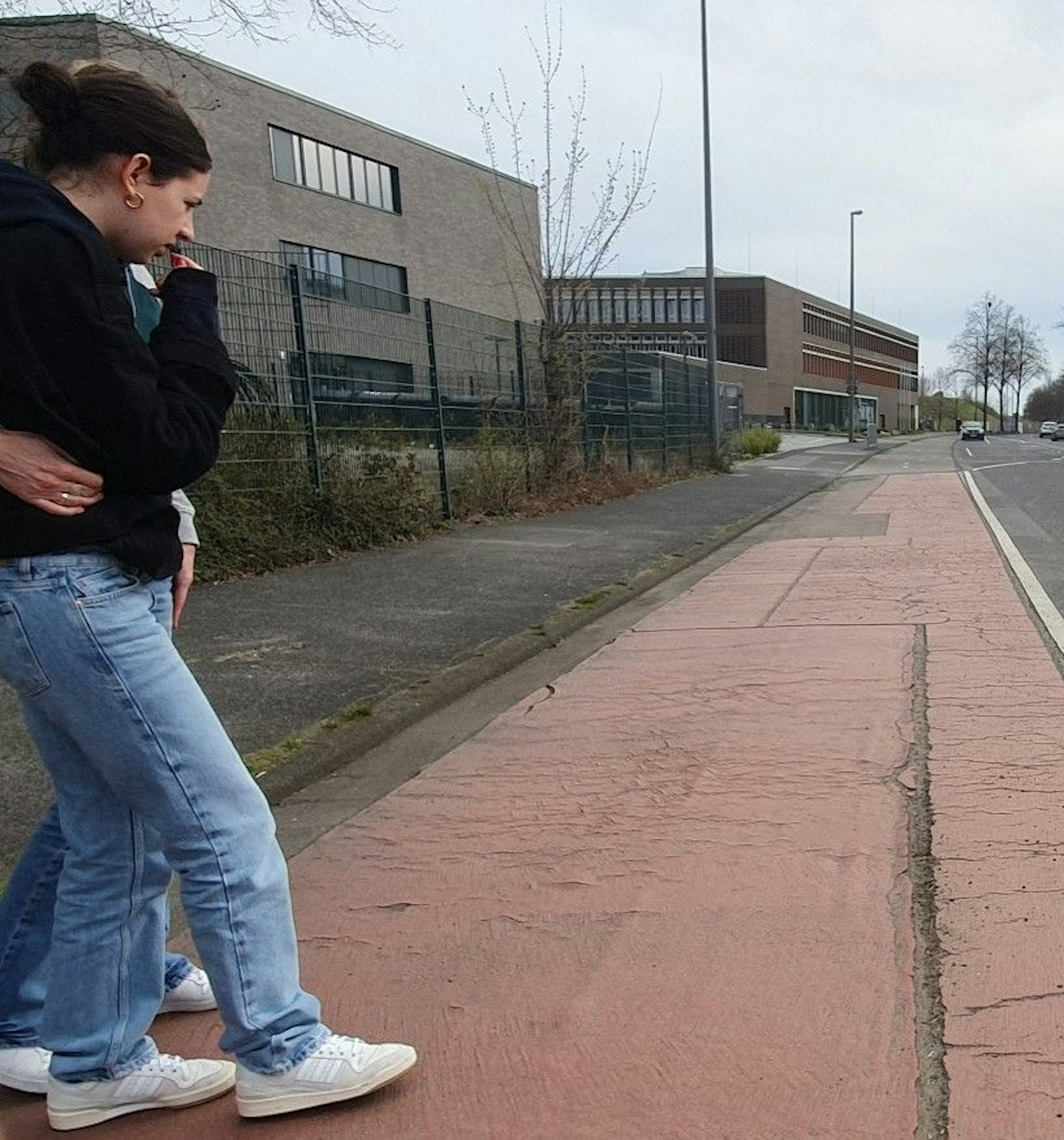 Mathilda Koßmann und eine Begleiterin schauen auf die Rille im Radweg.