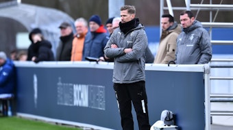 Trainer der U19 von Borussia Mönchengladbach verschränkt die Arme in der Coaching-Zone.