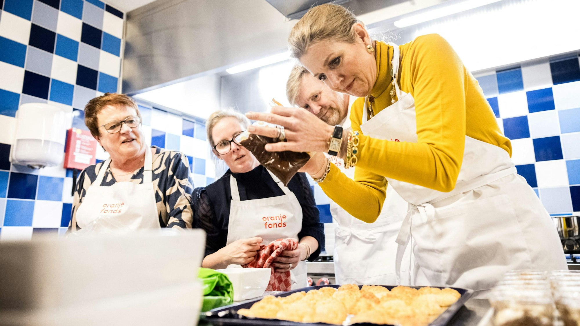 König Willem-Alexander und Königin Maxima arbeiten während der 20. Ausgabe von NLdoet, der größten Freiwilligenkampagne in den Niederlanden, ehrenamtlich in einer Küche.