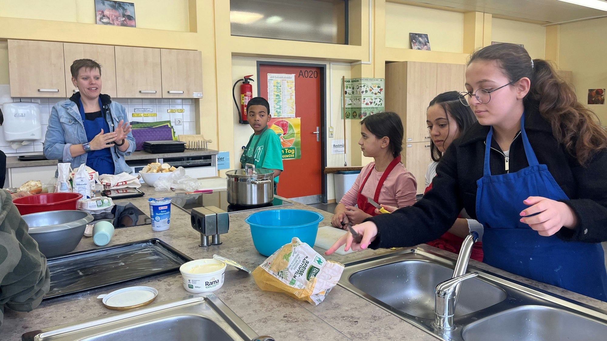 Schülerinnen und Schüler kochen gemeinsam in der Schulküche.