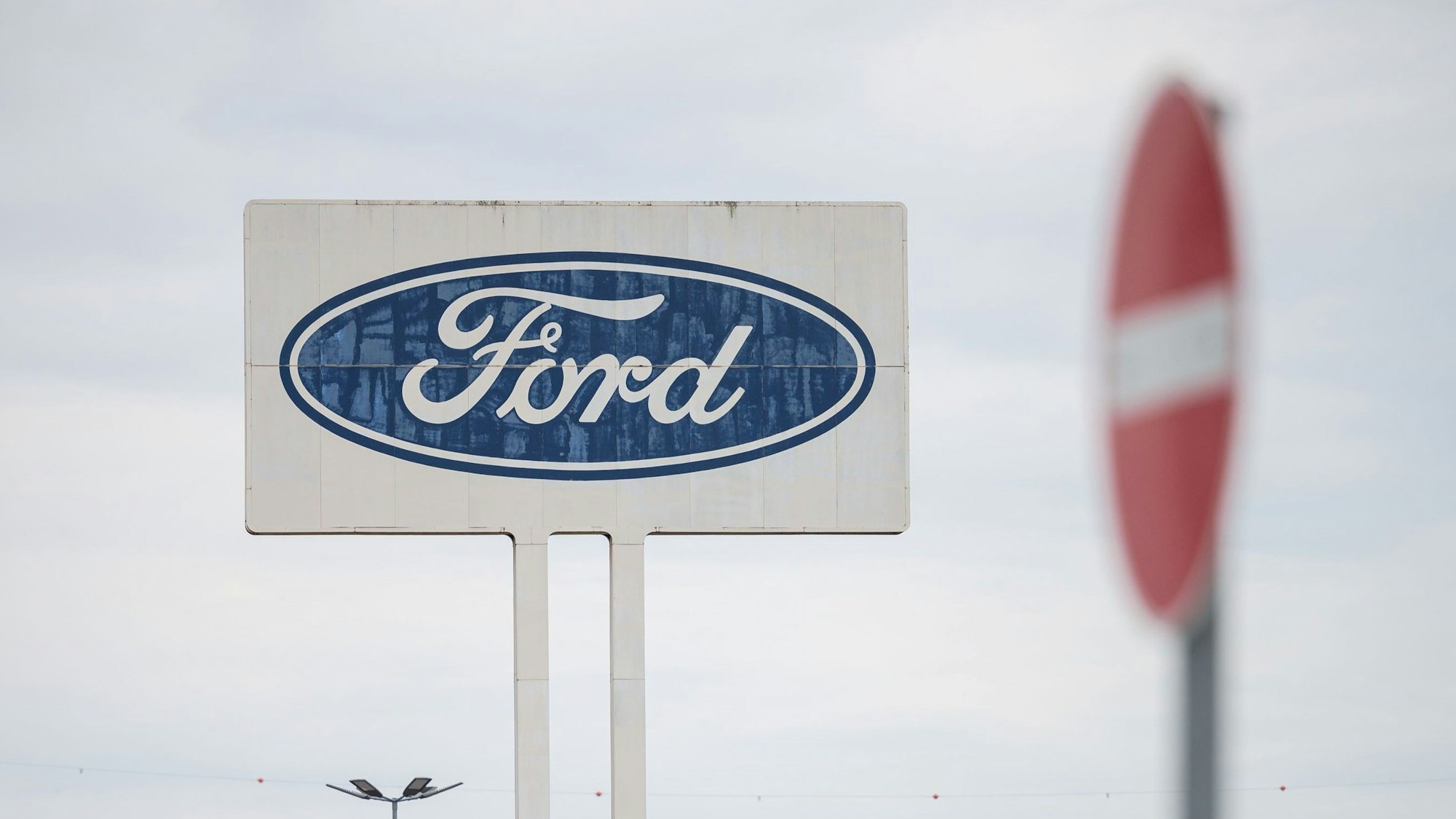 Das große Logo von Ford, das auf dem Parkplatz des Werks Saarlouis steht, mit einem Durchfahrt Verboten Schild davor.