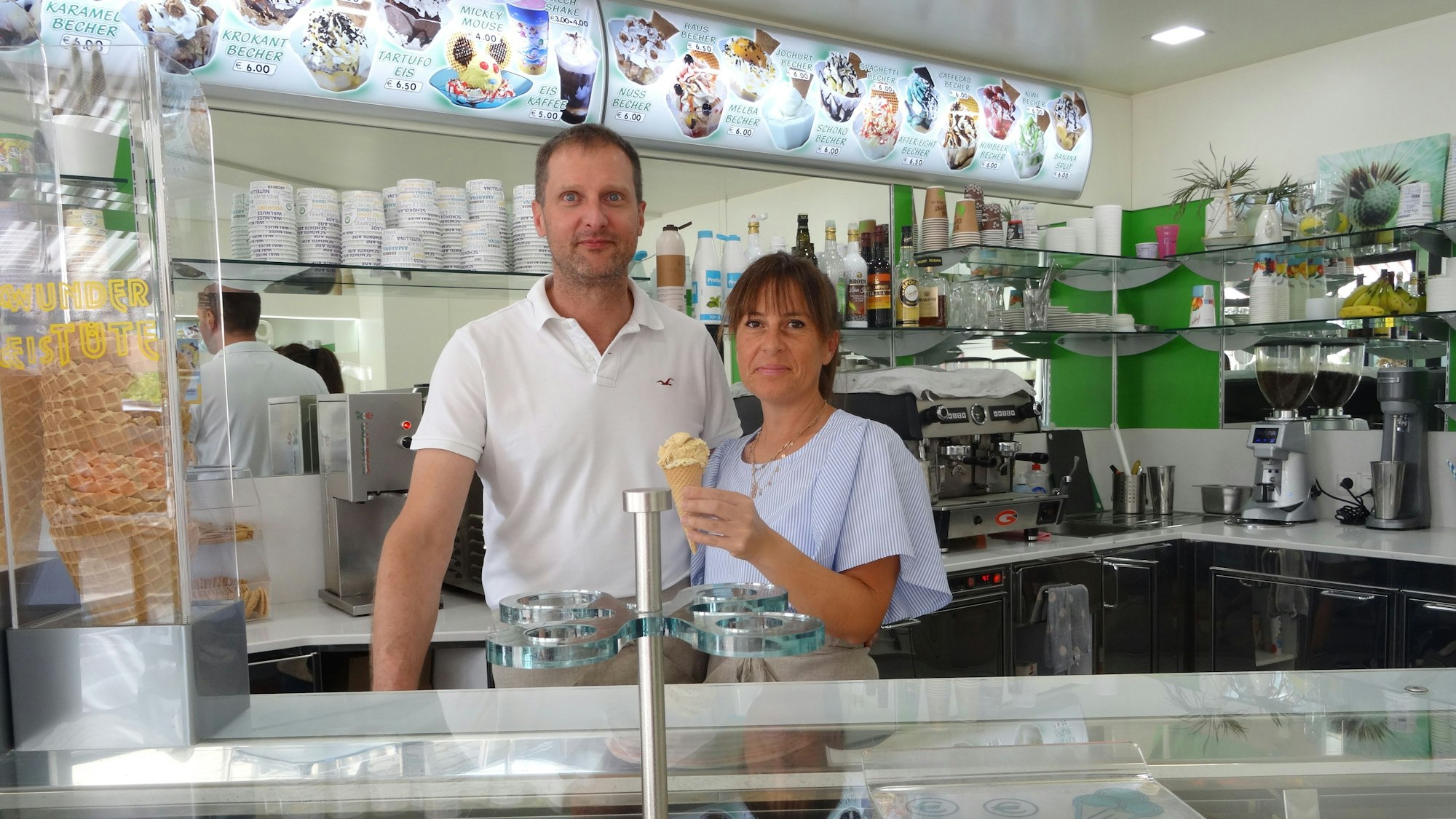 Francesco Provvedi und Sonia Becchetti führen das Eiscafé Panciera in Neunkirchen-Seelscheid. Auf dem Bild stehen sie hinter der Eistheke und schauen in Richtung der Kamera.