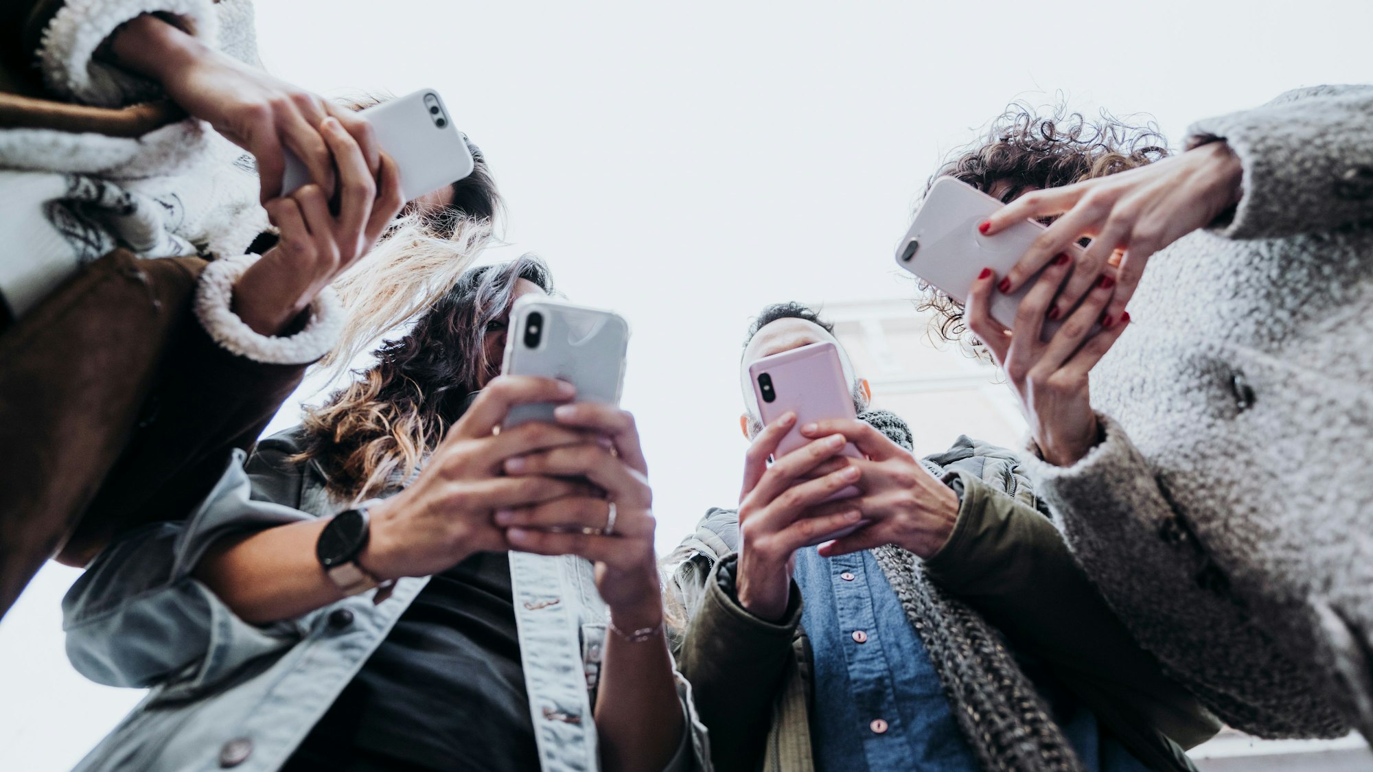 Eine Gruppe Freunde guckt auf ihre Smartphones
