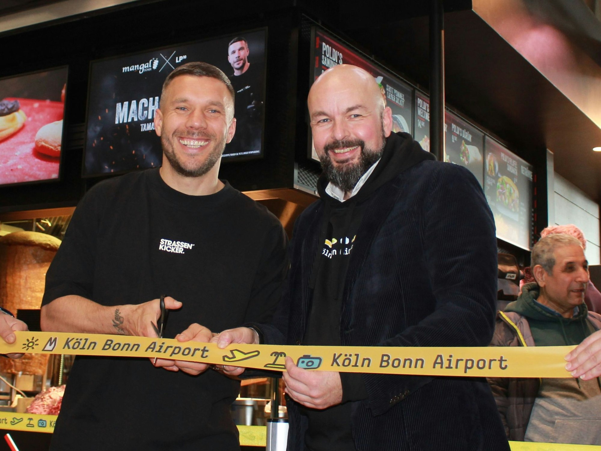 Lukas Podolski und Thilo Schmid, Vorsitzender der Geschäftsführung der Flughafen Köln/Bonn GmbH