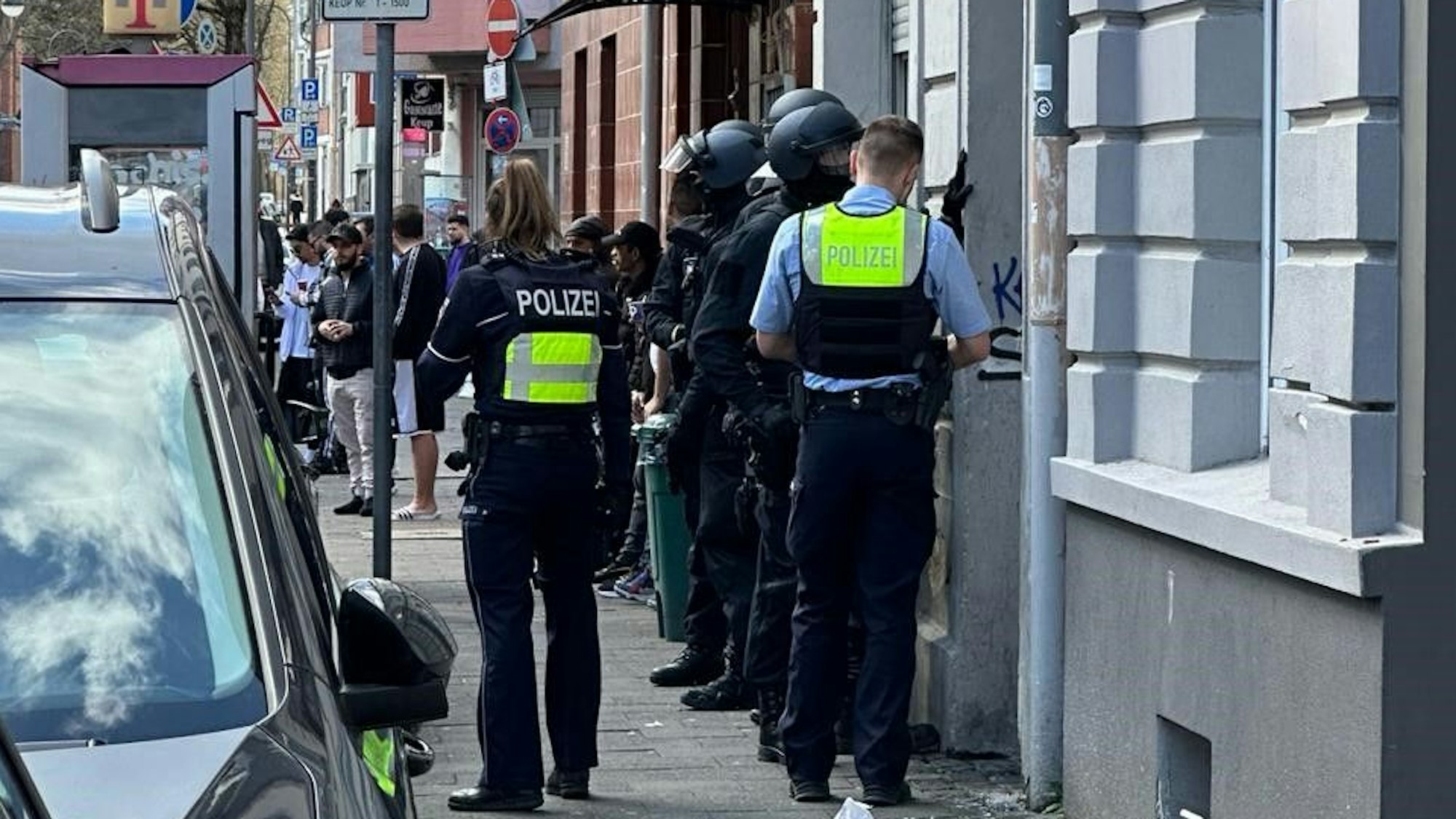Polizisten betreten am Montag (18. März) ein Wohnhaus an der Holweider Straße. Ein 20-Jähriger wurde festgenommen.