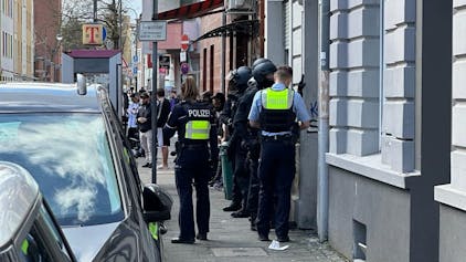 Polizisten betreten am Montag (18. März) ein Wohnhaus an der Holweider Straße. Ein 20-Jähriger wurde festgenommen.