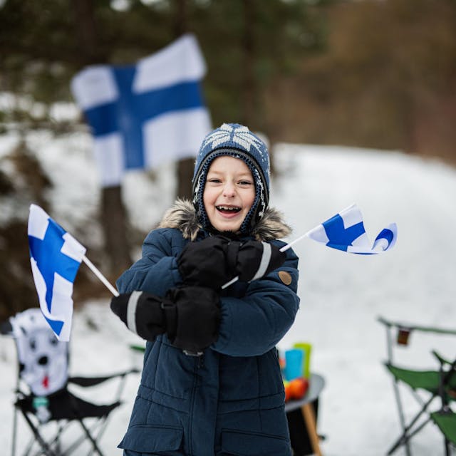 Finnish boy with Finland flags on a nice winter day. Nordic Scandinavian people.