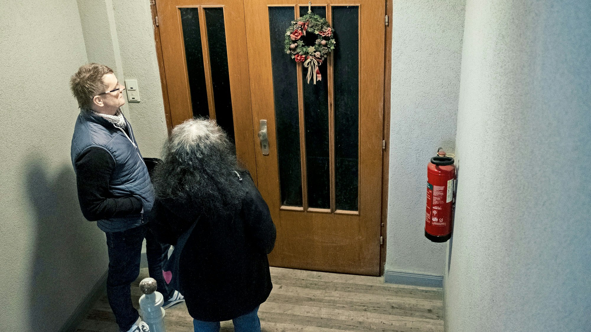 Fatma Edeer-Cetin und Sascha Riepel vom Jobcenter Kassel stehen vor einer Wohnungstür, an der noch im März Weihnachtsschmuck zu sehen ist:  ein Hinweis darauf, dass die gesuchte Person möglicherweise ausgezogen ist.

(Foto: Jonas Dengler)