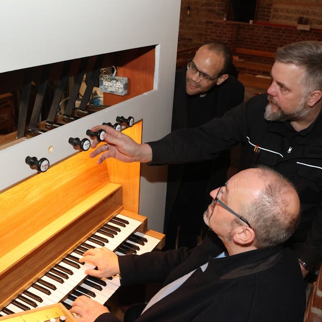 Martin Hiltmann (Mite) erklärt Dr. Dirk van Betteray (sitzend) und Pastor Tobias Zöller die neue Orgel.