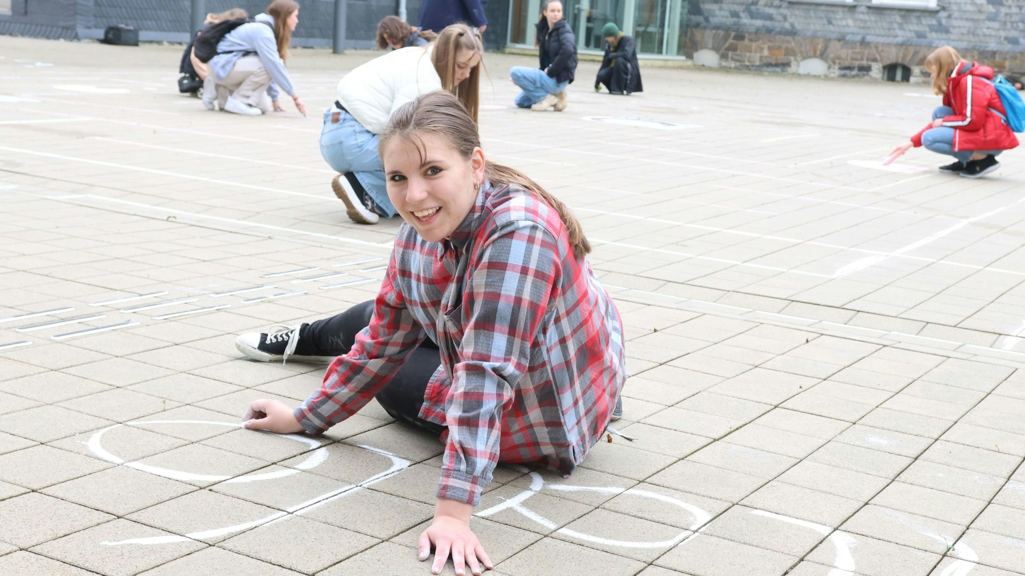 Schülerin Lilly (15) von der städtischen Gesamtschule gehörte zu der Gruppe, die am Donnerstag im Waldbröler Bürgerdorf am Alsberg ein „Pac-Man“-Spiel mit Kreise aufs Pflaster gebracht hat.
