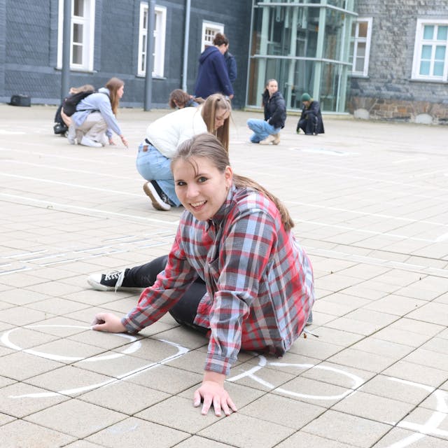 Schülerin Lilly (15) von der städtischen Gesamtschule gehörte zu der Gruppe, die am Donnerstag im Waldbröler Bürgerdorf am Alsberg ein „Pac-Man“-Spiel mit Kreise aufs Pflaster gebracht hat.