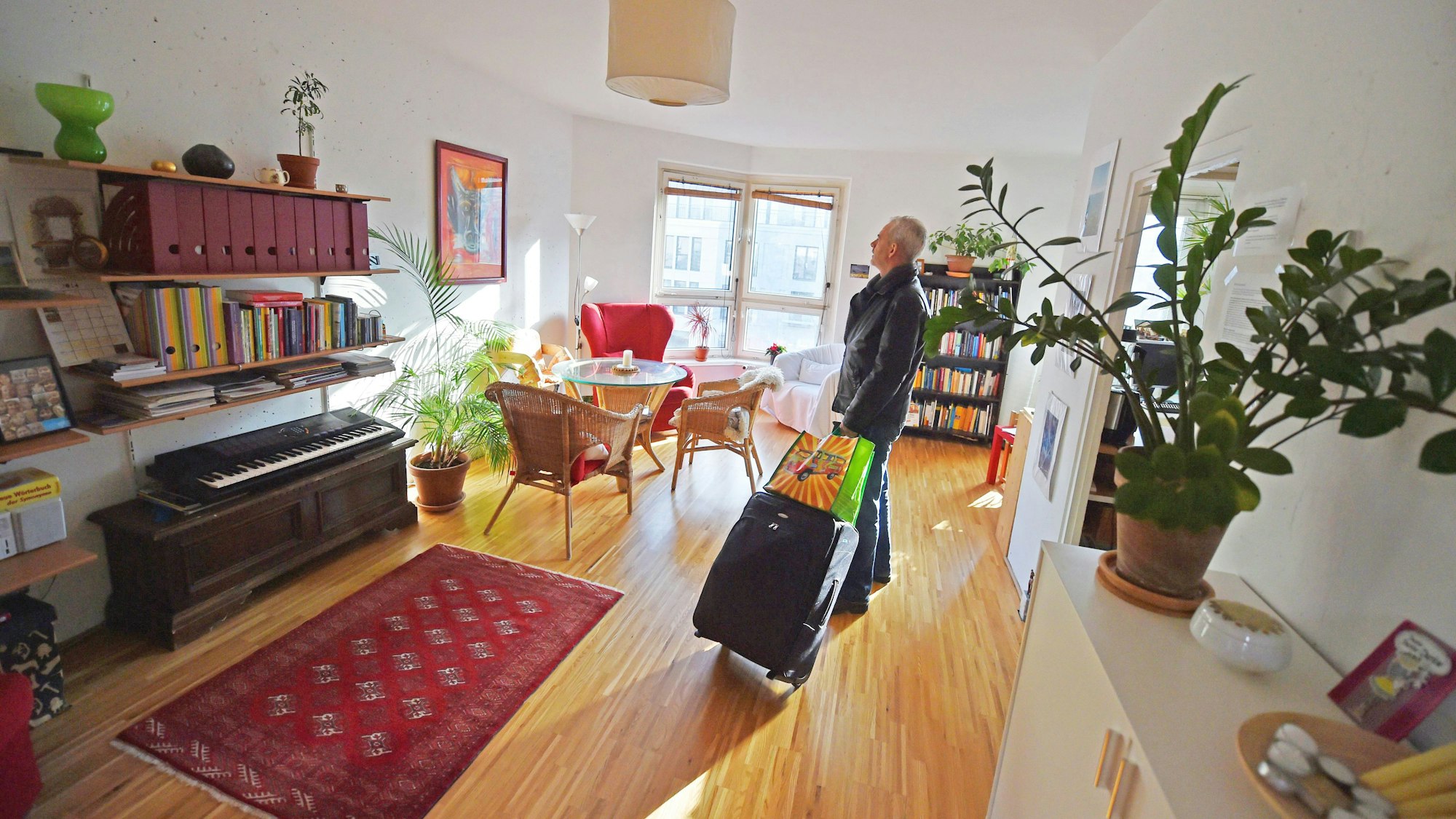 Ein Tourist, der eine Übernachtung über das Onlineportal Airbnb gebucht hat, kommt mit seinem Koffer in der gemieteten Wohnung an.