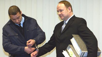 Jürgen Harksen (r.) lässt sich bei seinem Prozess 2003 die Handschellen abnehmen.