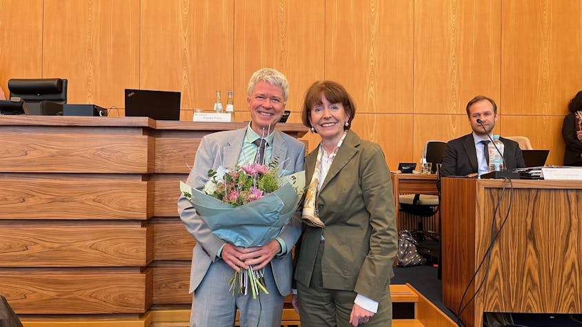 Harald Rau erhält steht mit einem Blumenstrauß neben Oberbürgermeisterin Henriette Reker.