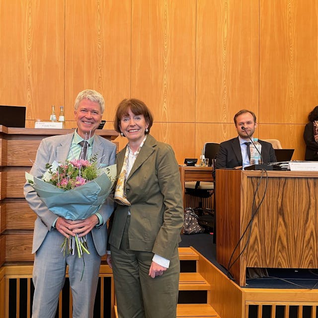 Harald Rau erhält steht mit einem Blumenstrauß neben Oberbürgermeisterin Henriette Reker.
