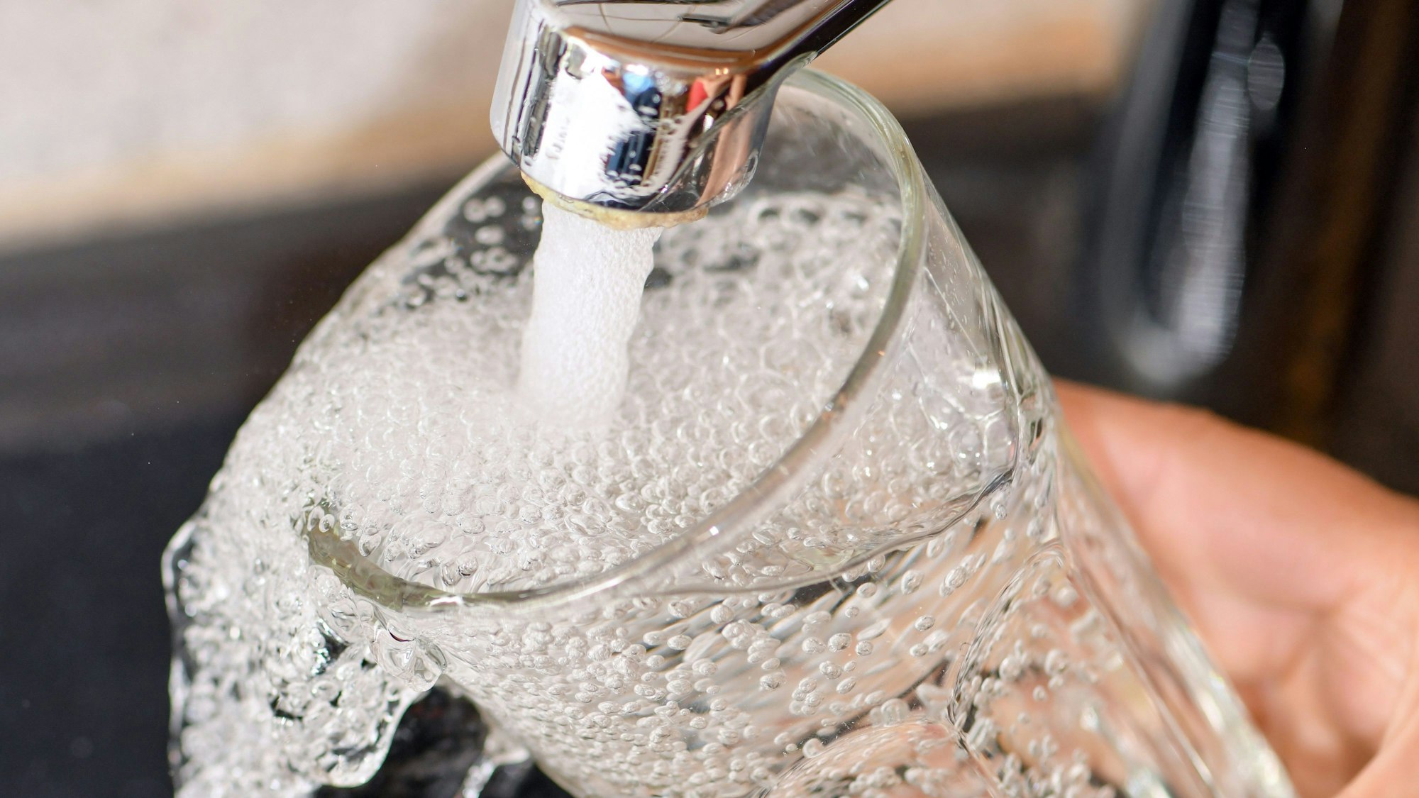 Am Wasserhahn in einer Küche wird ein Trinkglas mit Leitungswasser befüllt. dpa-Bildfunk +++