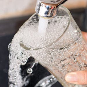 Am Wasserhahn in einer Küche wird ein Trinkglas mit Leitungswasser befüllt. dpa-Bildfunk +++
