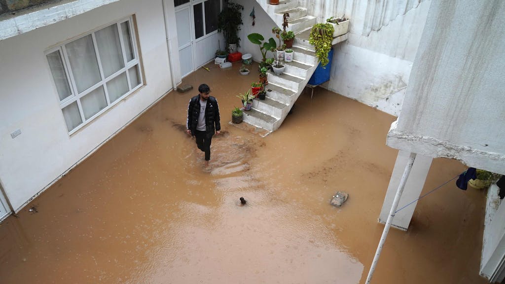 Das Foto zeigt einen überfluteten Hinterhof im irakischen Dohuk Mitte März: Mit fiktiven Wettervorhersagen aus dem Jahr 2050 wollen Kinder gemeinsam mit den UN vor der Klimakrise warnen.