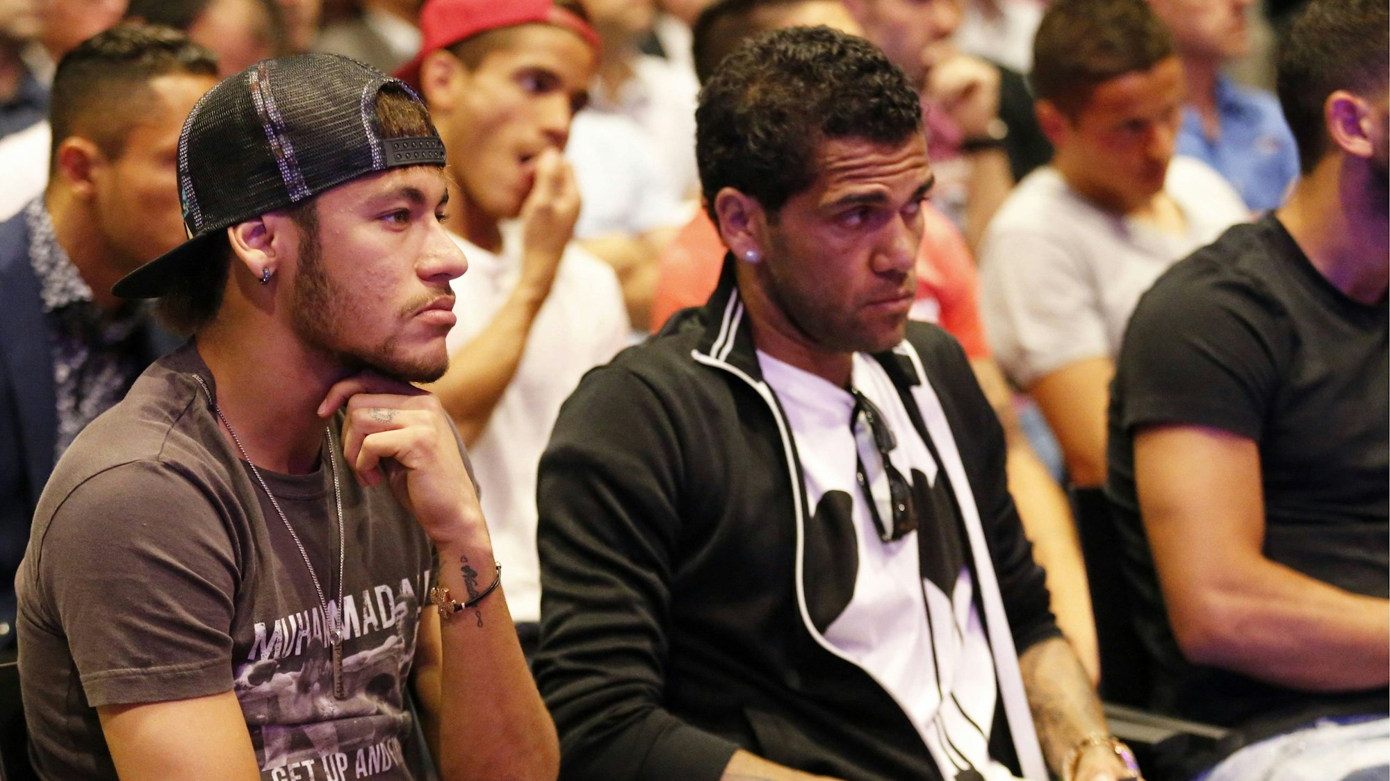 Neymar und Dani Alves sitzen nebeneinander bei einer Veranstaltung in Barcelona.