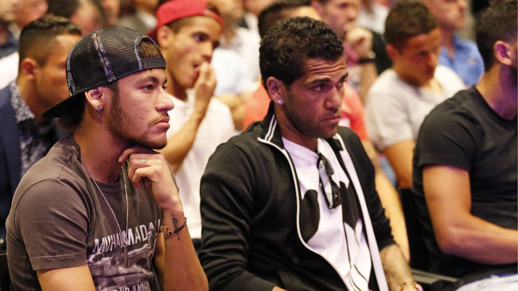Neymar und Dani Alves sitzen nebeneinander bei einer Veranstaltung in Barcelona.