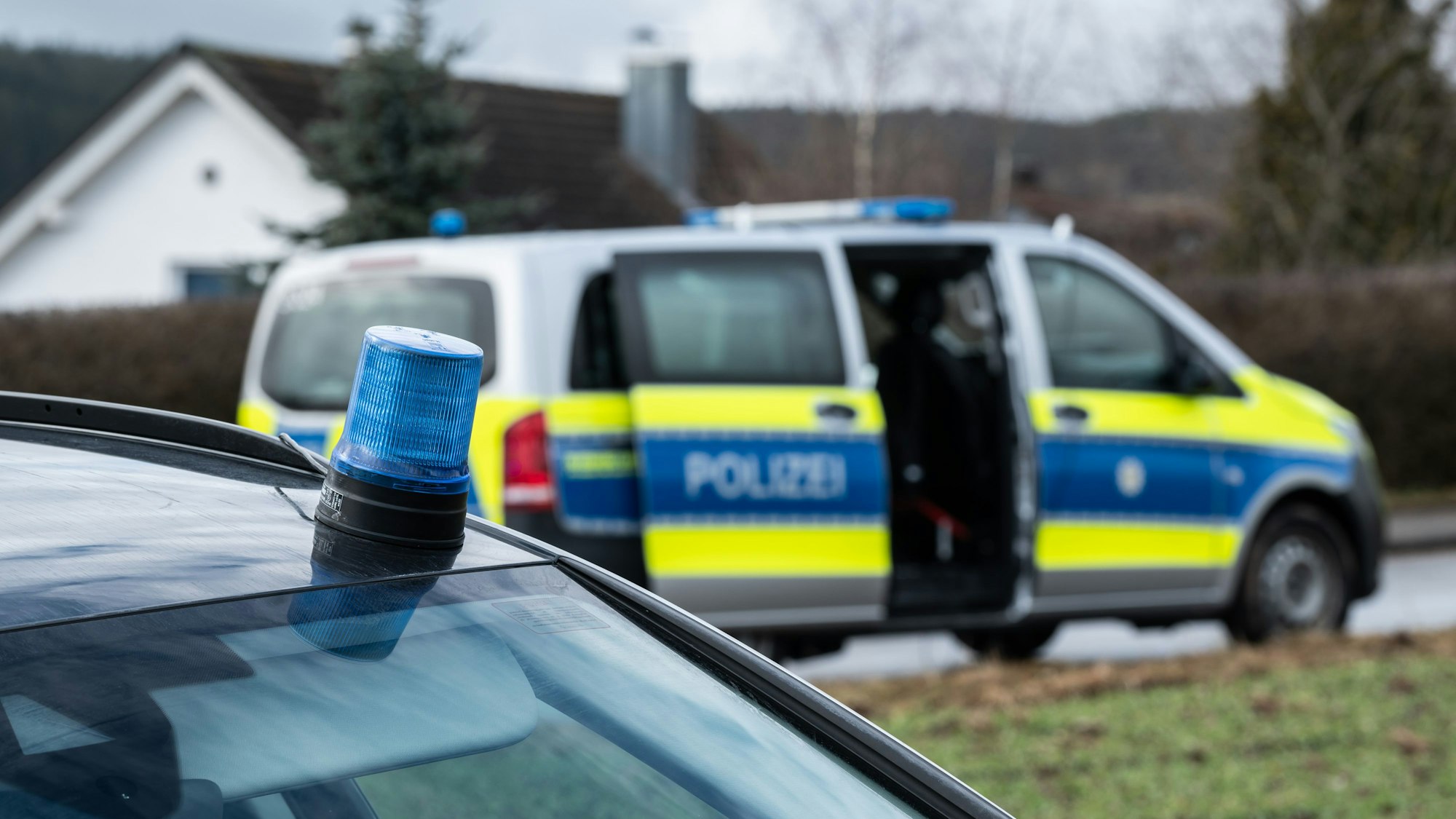 Einsatzfahrzeuge der Polizei stehen mit Blaulicht bei einem Wohngebiet (Symbolfoto).