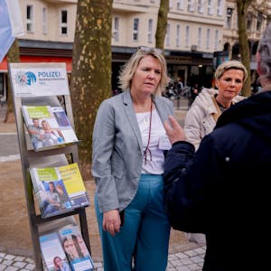 Das Foto zeigt Birgit Wunderlich (Opferschutz des Landes NRW) (links) und Anja Kleck (Kriminalprävention / Opferschutz Polizei Köln) im Gespräch mit einem Passanten.