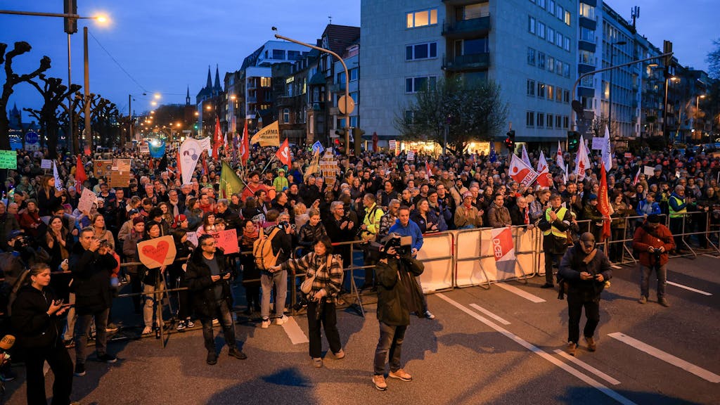 Tausende Menschen stehen in einem abgesperrten Bereich am Rheinufer in Köln und demonstrieren.